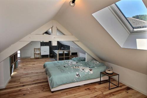 a attic bedroom with a bed and a window at Apt type 3 en Duplex sur EVIAN les Bains vue lac in Évian-les-Bains