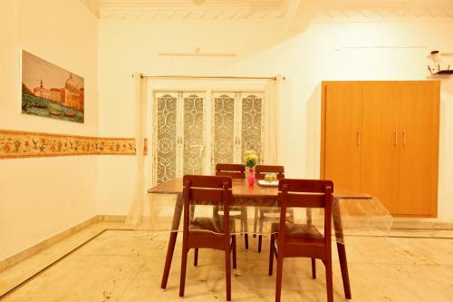 comedor con mesa de madera y sillas en BHARATHI RESIDHOME en Pondicherry