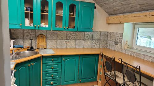 a kitchen with green cabinets and a sink at Kernavės centras in Kernavė