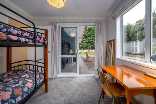 - une chambre avec un bureau et des lits superposés dans l'établissement Hare Cottage, à Martinborough