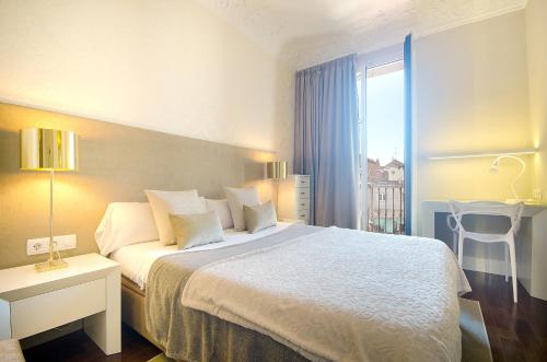 a hotel room with a large bed and a window at You Stylish Diagonal Apartments in Barcelona