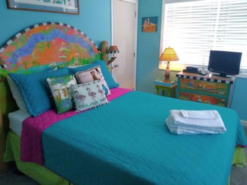a bedroom with a large bed with a blue bedspread at A18 Parrot Escape - OCEAN VIEW! There is nothing quite like a Carolina sunrise viewed from your private oceanfront deck condo in Carolina Beach