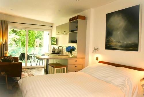 um quarto com uma cama e uma cozinha com uma mesa em The Coach House em Windermere