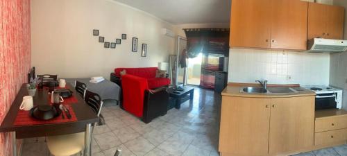 eine Küche und ein Wohnzimmer mit einem roten Sofa in der Unterkunft Hotel Loga in Tycherón