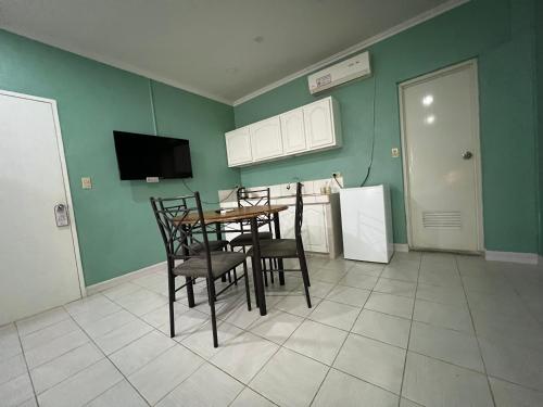 a kitchen with a table and chairs and a refrigerator at Beach Garden Hotel in Saipan