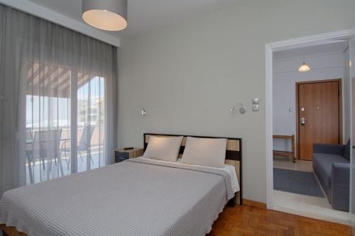 sypialnia z łóżkiem i dużym oknem w obiekcie MAHE APARTMENT w mieście Wolos