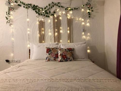 een slaapkamer met een wit bed met verlichting bij Studio in Riviera Sublime in Siolim