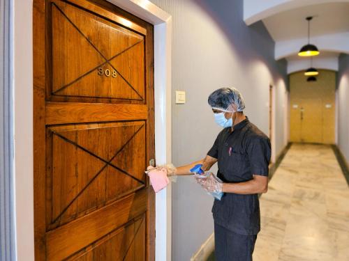 a man in a mask is opening a door at Shivani Palace Hotel, Restaurant & Party Hall in Seonī