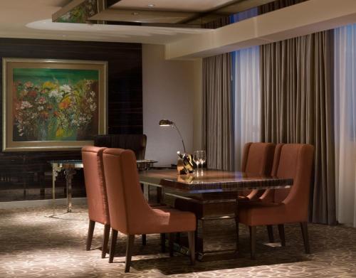 a dining room with a table and chairs and a painting at Novotel Bangka Hotel & Convention Center in Pangkalpinang