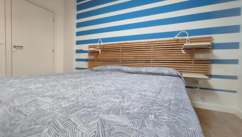 a bedroom with a bed and a striped wall at Casa Vacanze "Machí" in Senigallia