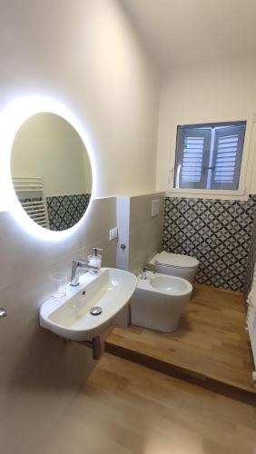 a bathroom with a sink and a toilet and a mirror at Casa Vacanze "Machí" in Senigallia