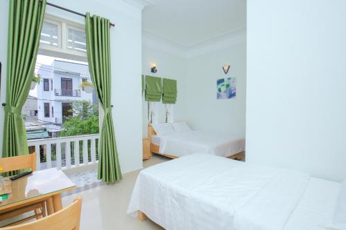 een slaapkamer met 2 bedden en een balkon bij Vân Mây Homestay Hội An in Hội An