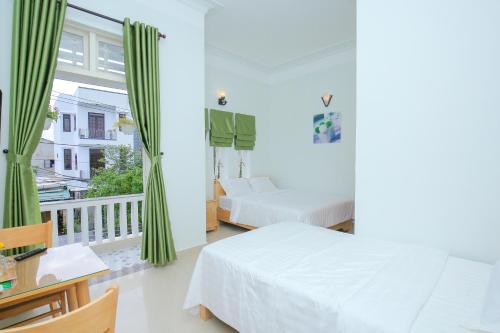 a bedroom with two beds and a balcony at Vân Mây Homestay Hội An in Hoi An