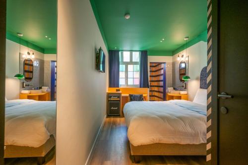 sypialnia z 2 łóżkami i zielonym sufitem w obiekcie P6 Antwerp w Antwerpii