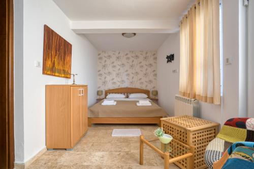 ein kleines Schlafzimmer mit einem Bett und einem Stuhl in der Unterkunft Apartman Marija LUX in Sveti Stefan