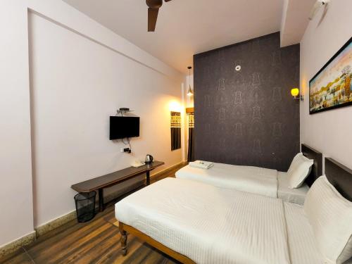 a room with two beds and a desk in it at Shivani Palace Hotel, Restaurant & Party Hall in Seonī