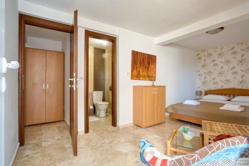 ein Schlafzimmer mit einem Bett und ein Badezimmer mit einem WC in der Unterkunft Apartman Marija LUX in Sveti Stefan