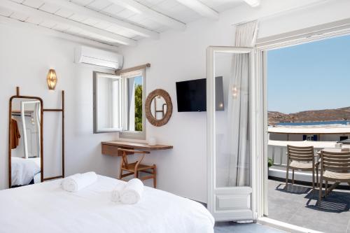 a bedroom with a bed and a view of a balcony at Nautilus Serifos in Livadakia
