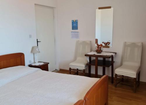 a bedroom with a bed and two chairs and a table at Guesthouse Lidija in Sutivan