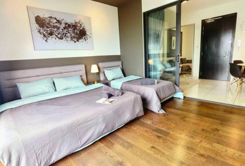 ヌサジャヤにあるAlmas Suites Youtube Netflix 100mbps By STAYの木製の床の部屋にベッドが2つあります