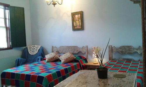 a bedroom with a bed and a chair and a table at Pouso Realeza in Tiradentes