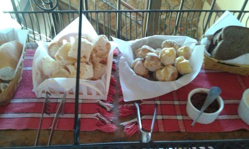 a table with a bunch of bread and pastries at Pouso Realeza in Tiradentes