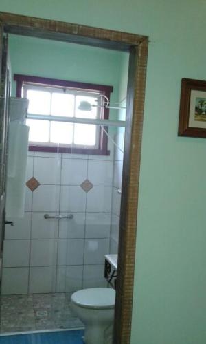 a bathroom with a toilet and a window at Pouso Realeza in Tiradentes