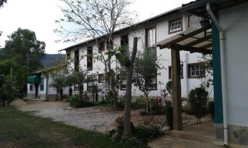 a white house with a tree in front of it at Pouso Realeza in Tiradentes