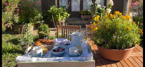 un tavolo con cibo e fiori in un giardino di Une envie de montagne a Guillestre