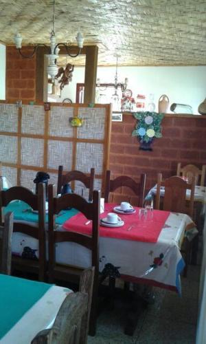 a dining room with a table with a red and white table cloth at Pouso Realeza in Tiradentes