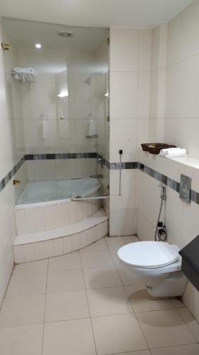 a bathroom with a tub and a toilet and a sink at hotel bessota international in Thiruvalla