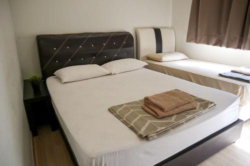 2 camas en una habitación con una toalla en la parte superior en HOT! Niki Adina - City Centre - Astro - MSU - WiFi, en Shah Alam