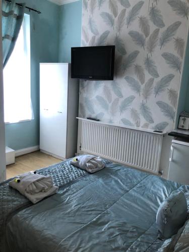 a bedroom with a bed with two towels on it at The Mayfair Hotel in Great Yarmouth