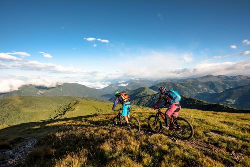 two people riding bikes on top of a mountain at Heimeliges Apartment in den Bergen in Bad Kleinkirchheim