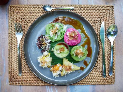 a plate of food with vegetables on a table at Bamboo Turtles Ecolodge in Ubud
