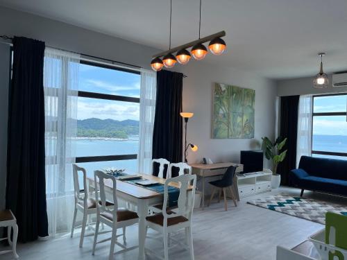 a living room with a table and chairs and a dining room at Mango House-PanoramaSeaView I Biggest unit I Wifi I WaterFilter I Latex I Gym-JQ in Kota Kinabalu