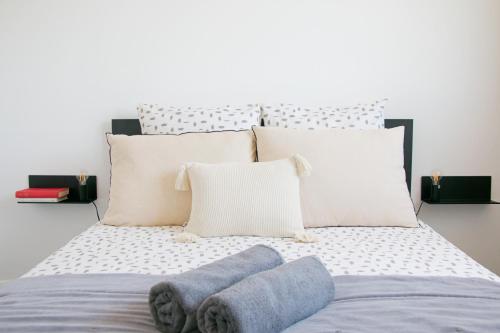 a bed with white pillows and blue socks on it at Air'BABY - 1 à 6 PERSONNES - Colomiers Centre in Colomiers