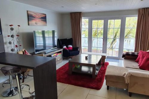 a living room with a couch and a table at Charming Lake House nature retreat in Cotswold Water Park, South Cerney near Cirencester in Cirencester