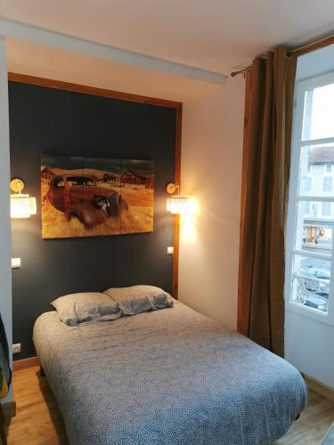une chambre avec un lit et un tableau au mur dans l'établissement Centre Confolens studios rénovés, à Confolens