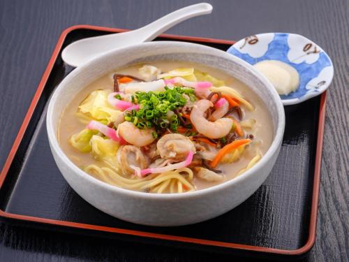 a bowl of soup with shrimp and vegetables on a tray at SPA HOTEL YUTTARIKAN in Satsumasendai