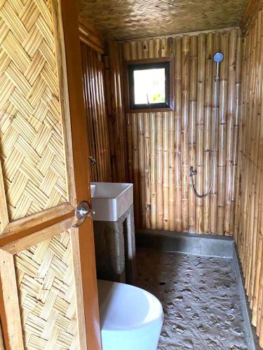 a wooden bathroom with a toilet and a sink at OcamOcam Azur Inn in Busuanga