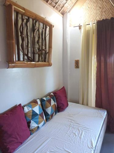 a small bed in a room with a window at OcamOcam Azur Inn in Busuanga