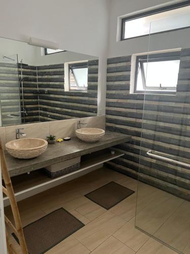 a bathroom with two sinks and a shower at Villa de Luxe Mon Voyage 500m de la plage in Albion
