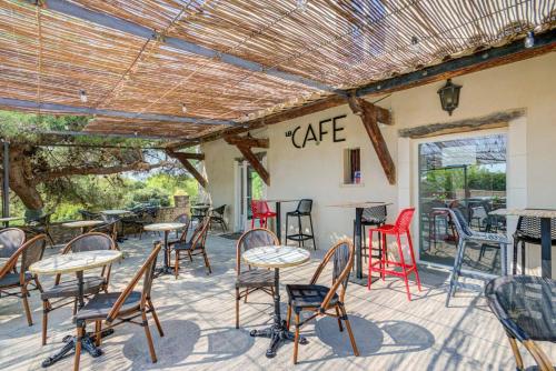 um pátio com mesas e cadeiras em frente a um café em Vilajoun em Joucas
