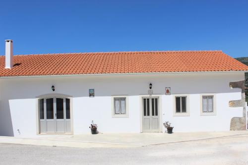 a white building with an orange roof at Casa do Avô Pedro in Lagar Novo