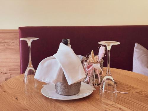 a table with a plate with a napkin and wine glasses at Hotel Kärnten in Krumpendorf am Wörthersee