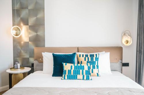 a bedroom with a bed with blue and white pillows at Apartments Eneida in Ulcinj