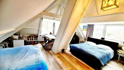 - une chambre mansardée avec un lit et un bureau dans l'établissement The Blue Dodo, à Zandvoort