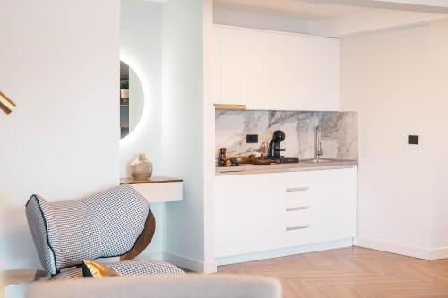 a living room with white cabinets and a chair at Apartments Eneida in Ulcinj