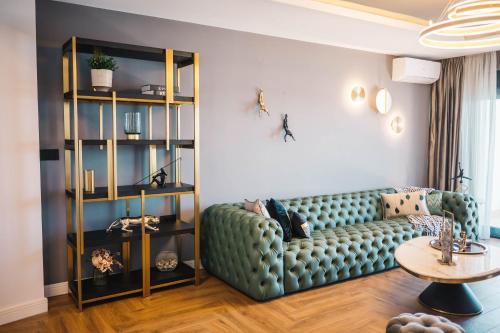 a living room with a green couch and a table at Apartments Eneida in Ulcinj